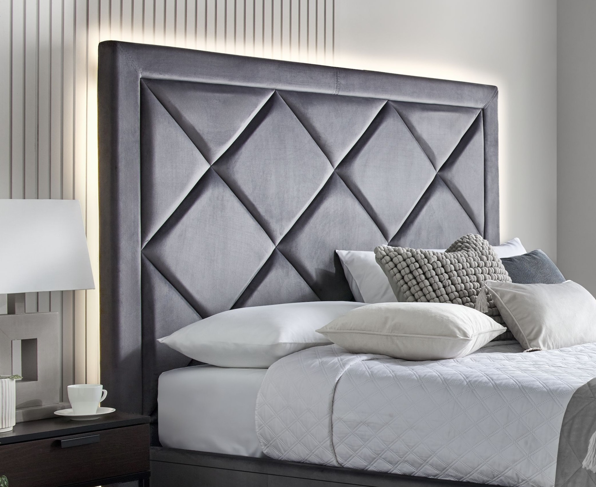 Detail of a grey upholstered TV Bed in a calm bedroom